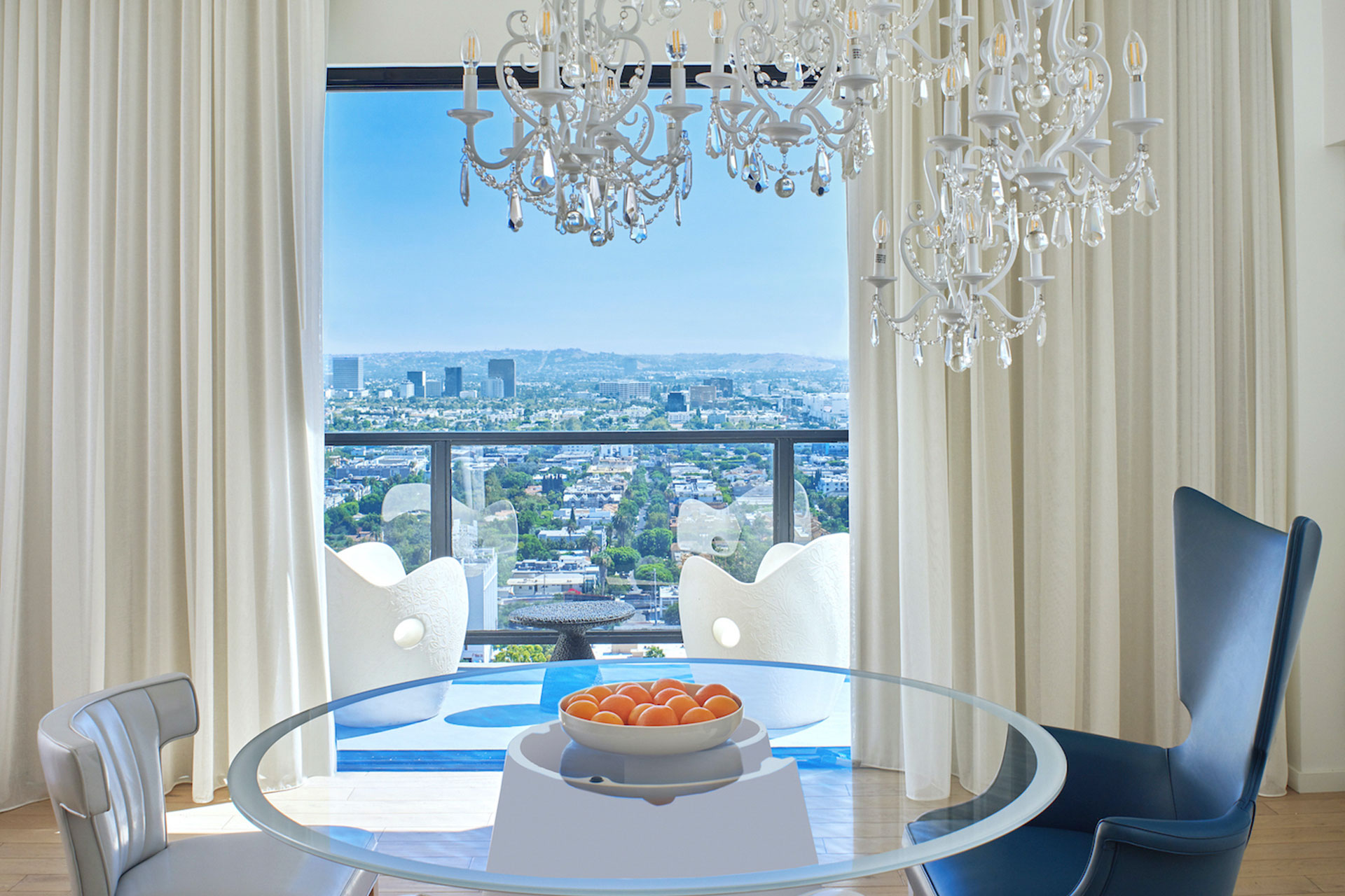 Mesa con frutero y silla y balcón con vistas a Los Ángeles.