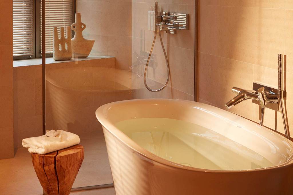 Salle de bains spacieuse avec une baignoire et une douche vitrée.