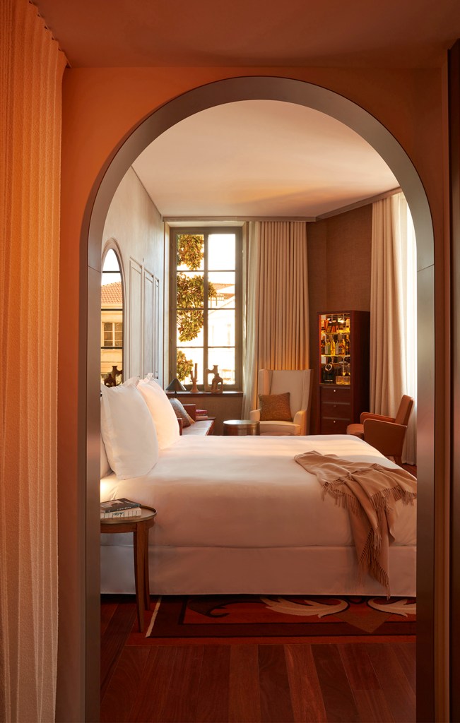 Chambre confortable avec un lit, une chaise, une table et une fenêtre ouvrant sur une vue sereine.
