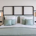 Luxurious bed with light blue bedding and black frame