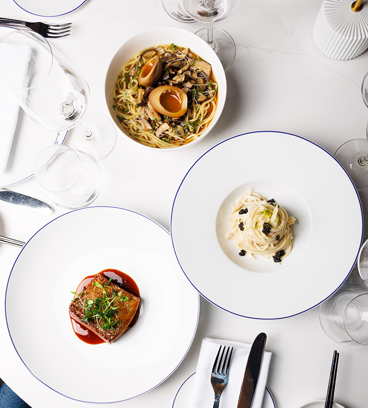 Three plates of food in a restaurant, captured from overhead