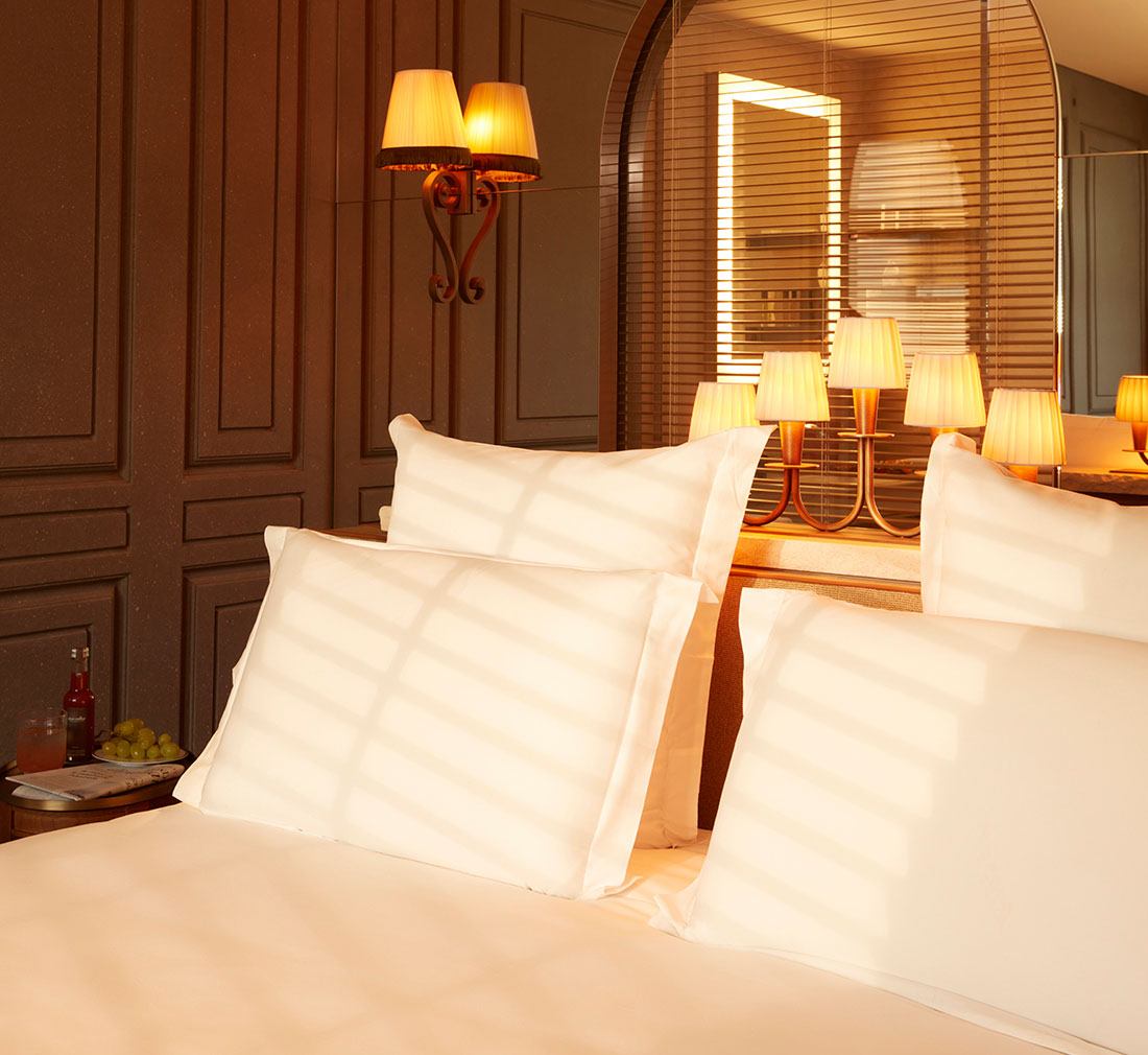 A neatly made bed with white sheets and pillows.