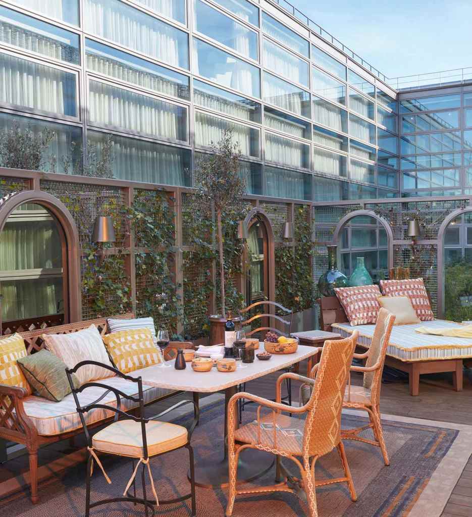 Patio avec une table et des chaises, offrant un coin salon extérieur confortable.