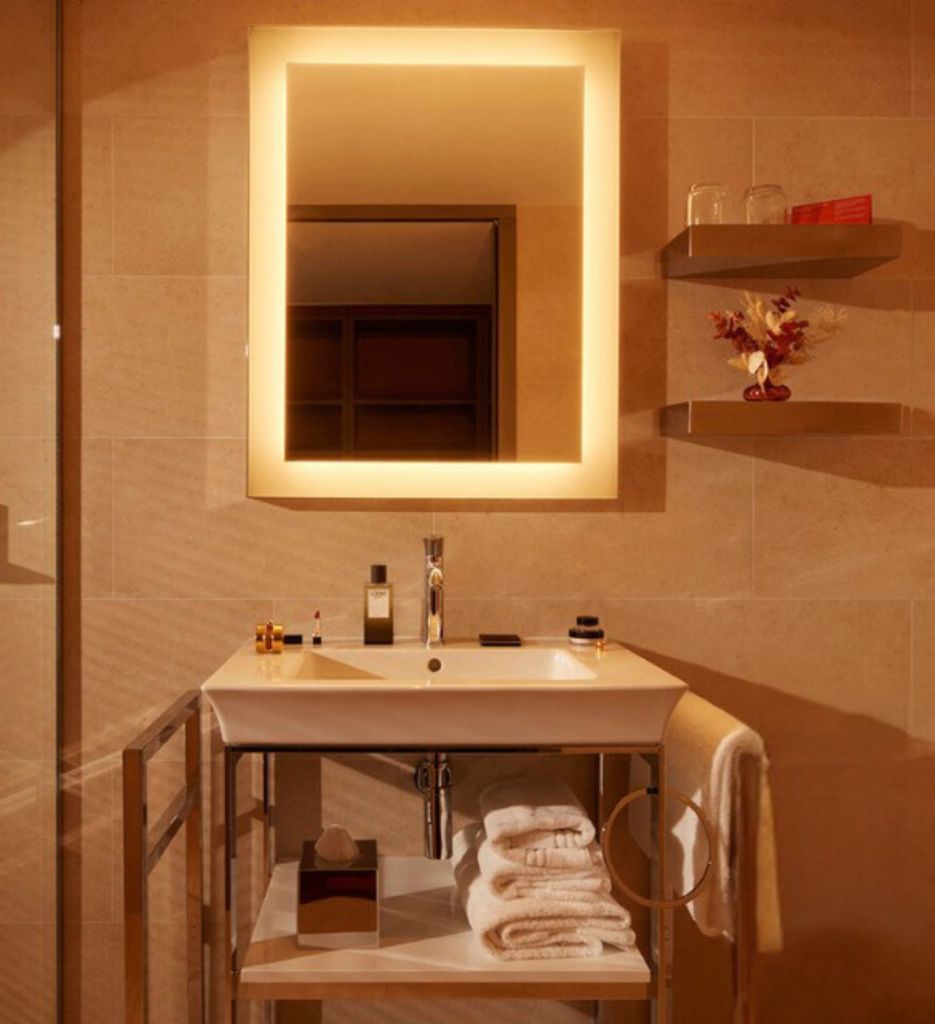 Bathroom sink and vanity with a square mirror that is lit up around its edges