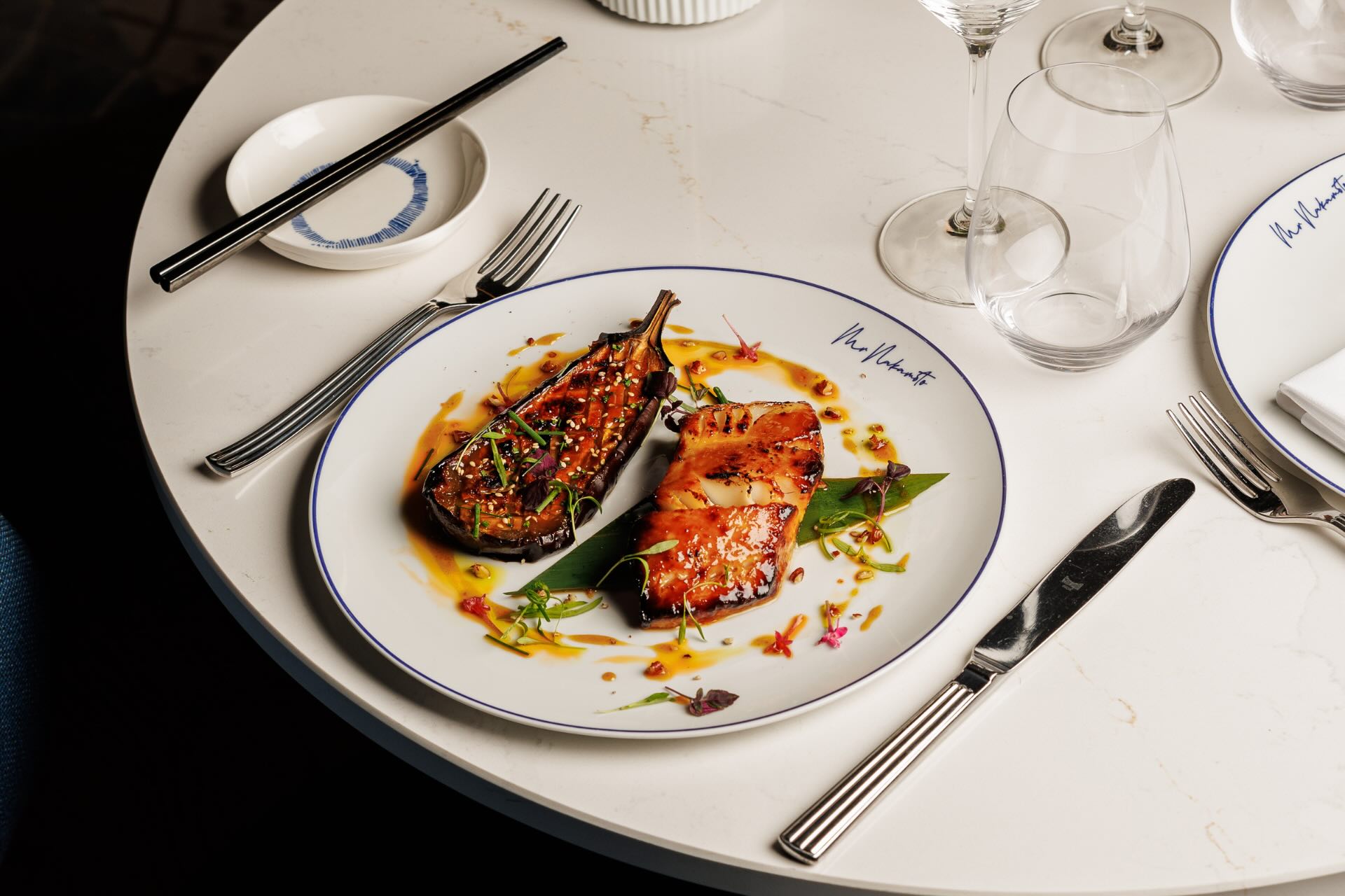 Une chaise bleue à une table dressée avec une assiette de nourriture dans un restaurant