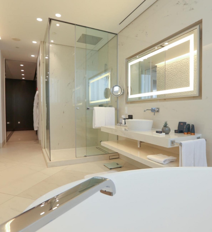 Bathroom with a tub, shower, sink and large wall mirror