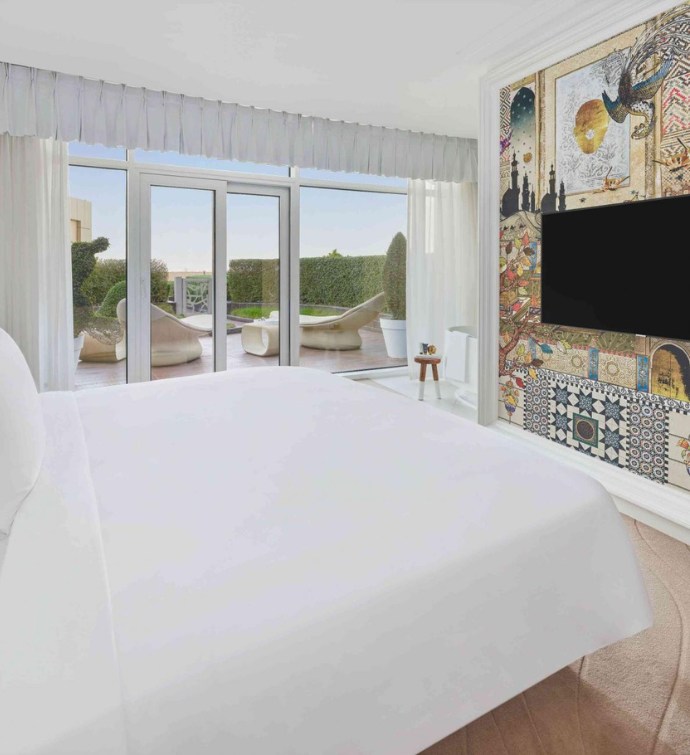 Bedroom with a colorful wall mural, tv and gorgeous view from a balcony 