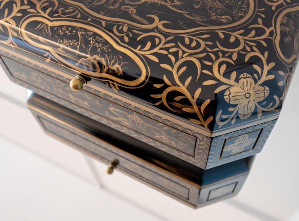 Close up image of intricately gold and black painted minibar chest