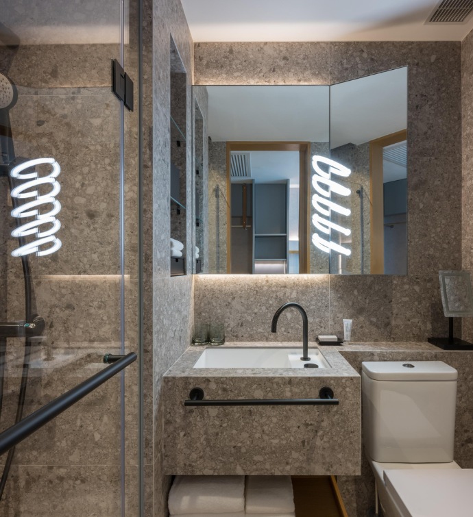 Marble and glass bathroom with light and a sink