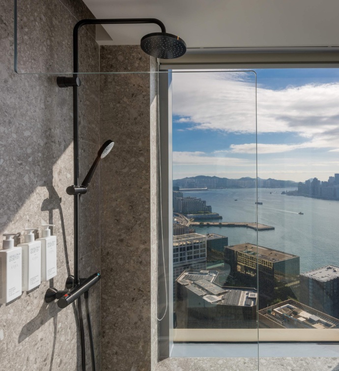 Bathroom with stone walls, rainfall shower and harbor views. 