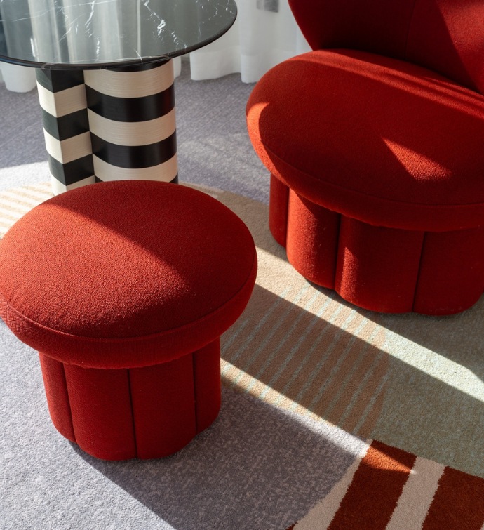 Red stools with a table with black and white stripes on the base