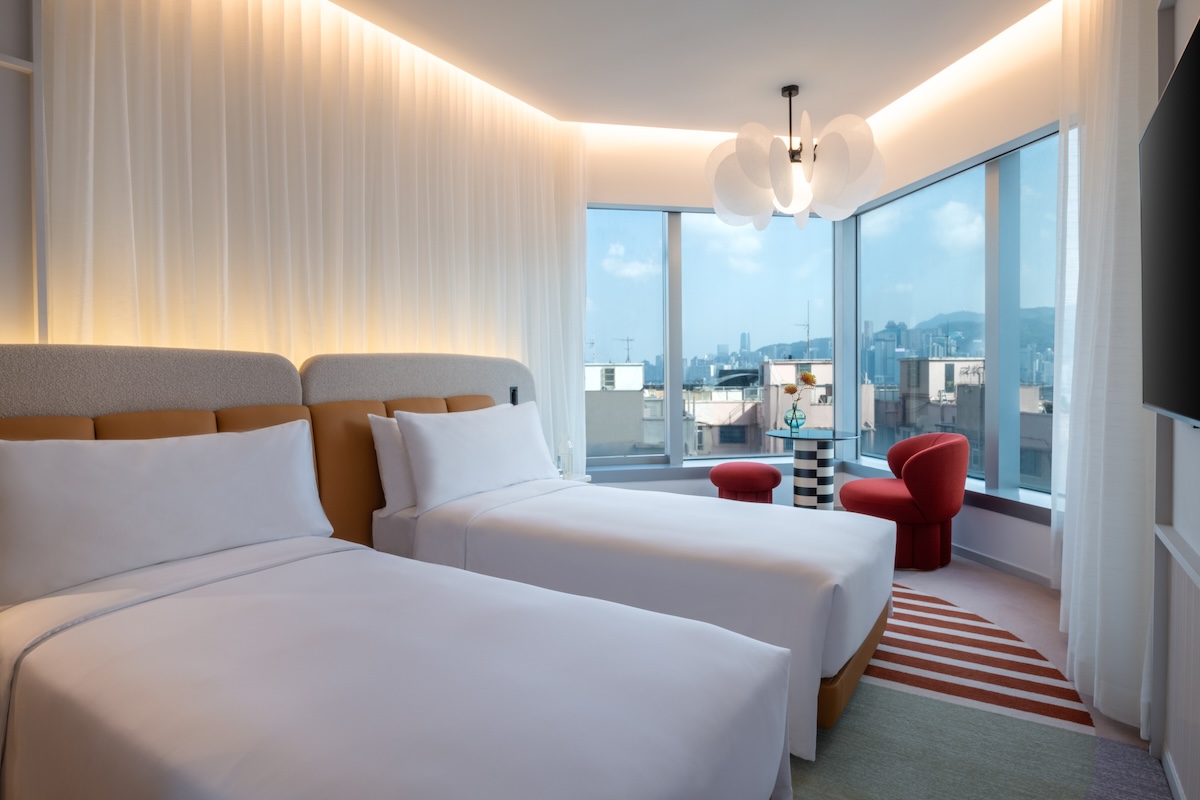 Two twin beds with a window looking out to city views