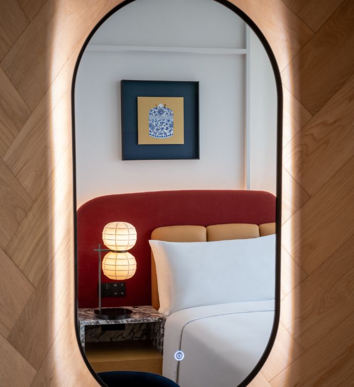 Mirror with a reflection of a bed in it