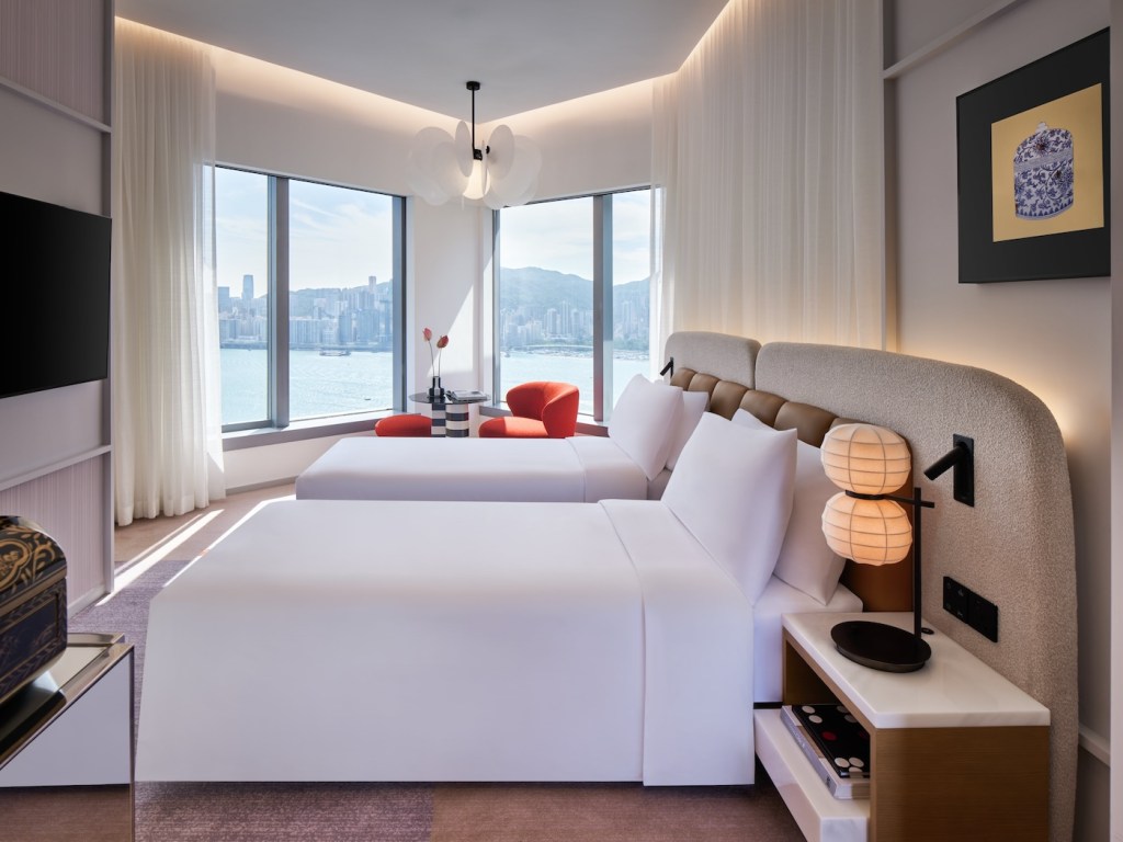 Two twin beds with a window looking out to city views