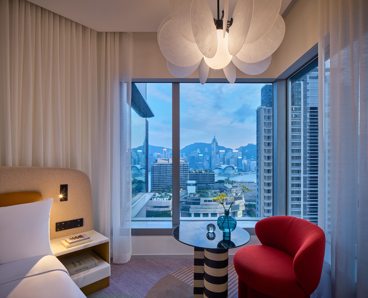 Small black and white striped table with red chairs and window to city behind it