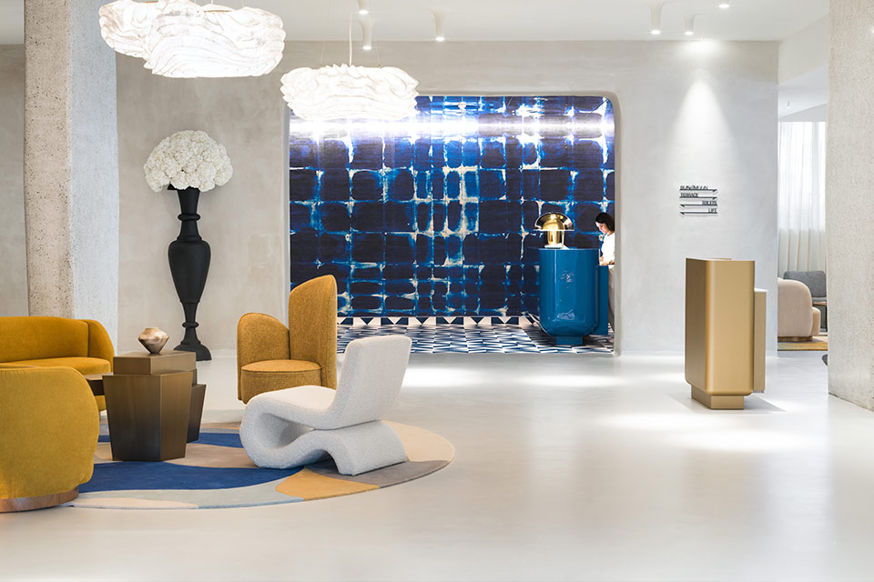 Mondrian Ibiza hotel lobby with blue walls in the reception area, and a modern seating area with sleek furniture.