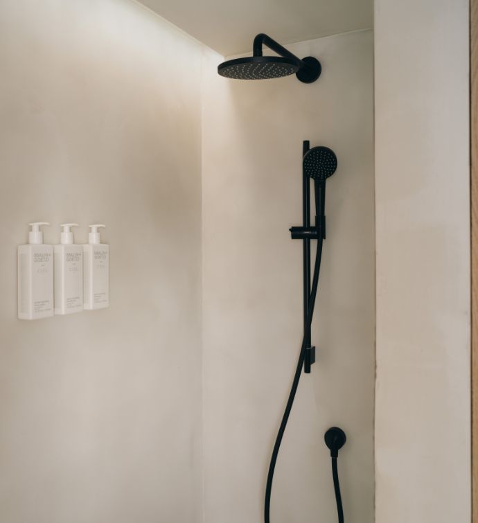 White/cream walk-in shower with black shower head and hardware