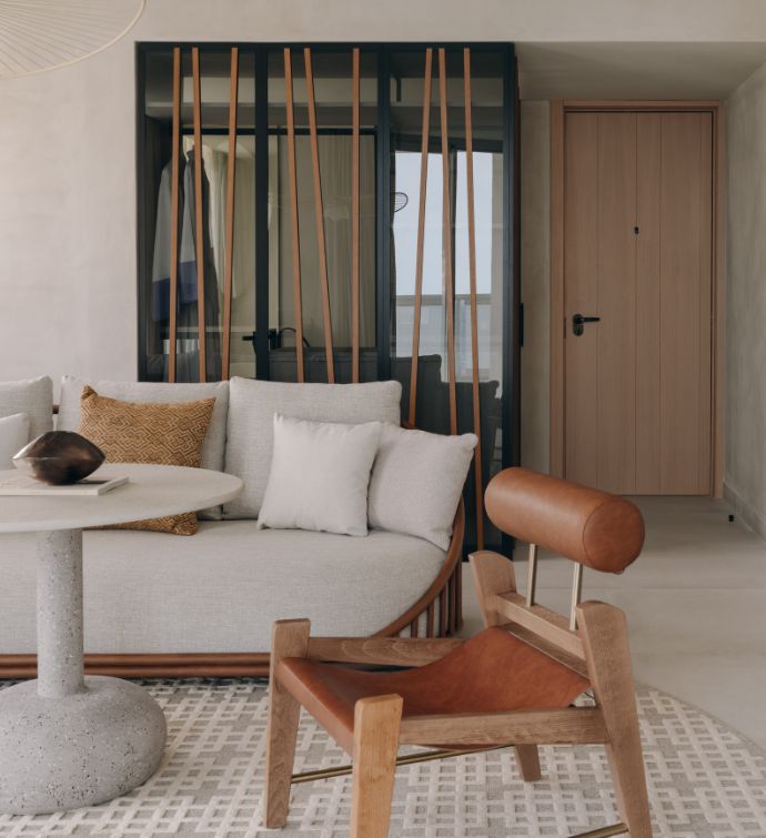 Cream sofa, white round table, and modern brown leather chair in a living area