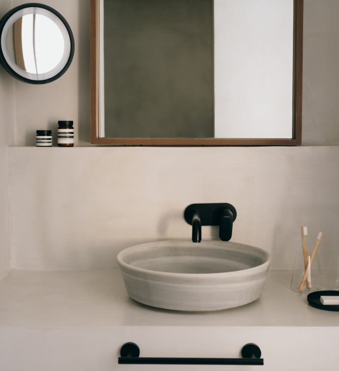 un cuarto de baño de diseño natural con un gran espejo de madera