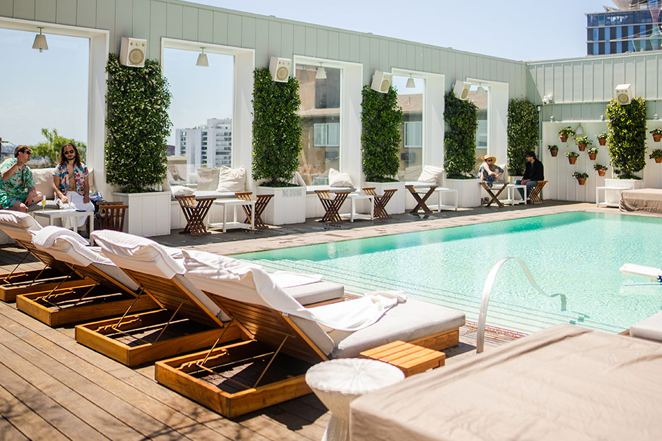 Piscina de Skybar LA en la azotea con tumbonas y grandes ventanales con vistas a Los Ángeles.