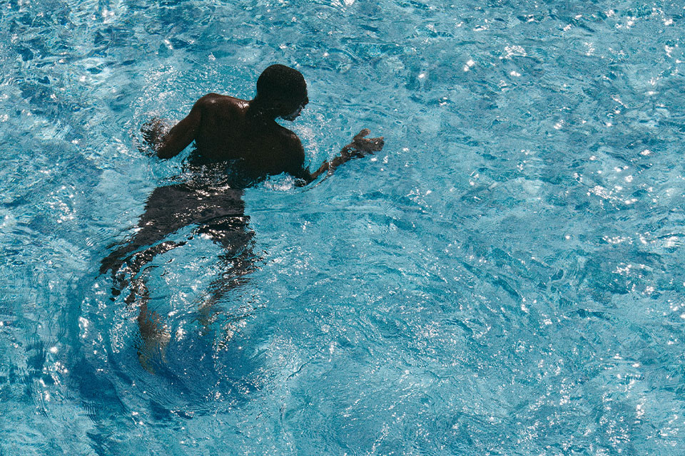 Hombre nadando en las aguas cristalinas de la piscina de Mondrian Los Angeles.