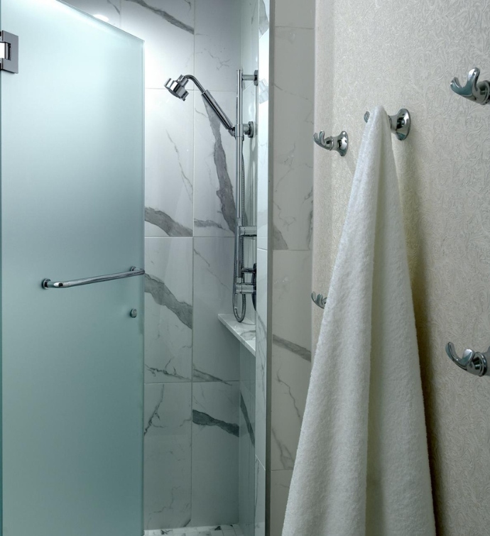 Glass shower with a towel hanging from a hook