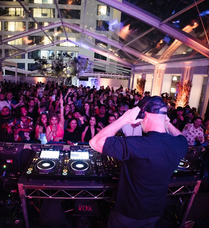 DJ performing in front of a crowd at night at Skybar LA