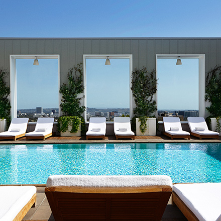 Piscina en la azotea de Skybar LA con tumbonas y vistas a la ciudad.