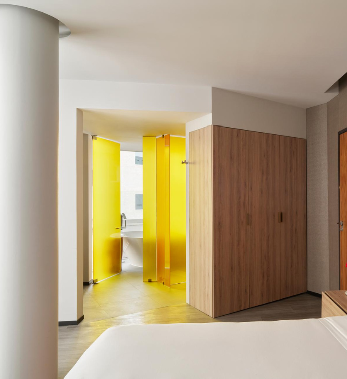 a sleek bedroom with yellow glass doors 