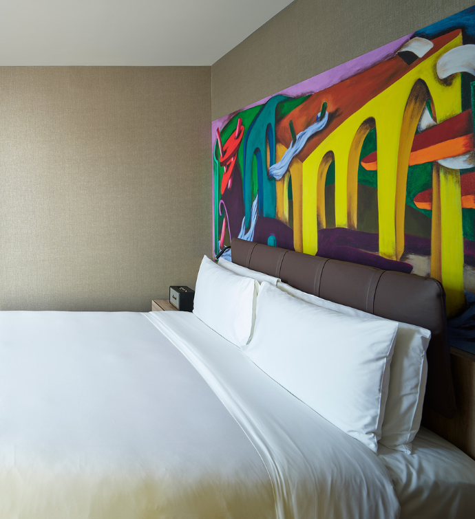 Hotel room at the Mondrian Mexico City Condesa with a bed and giant colorful wall mural