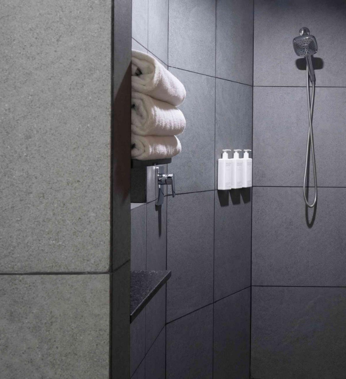 a modern shower with malin + goetz amenities