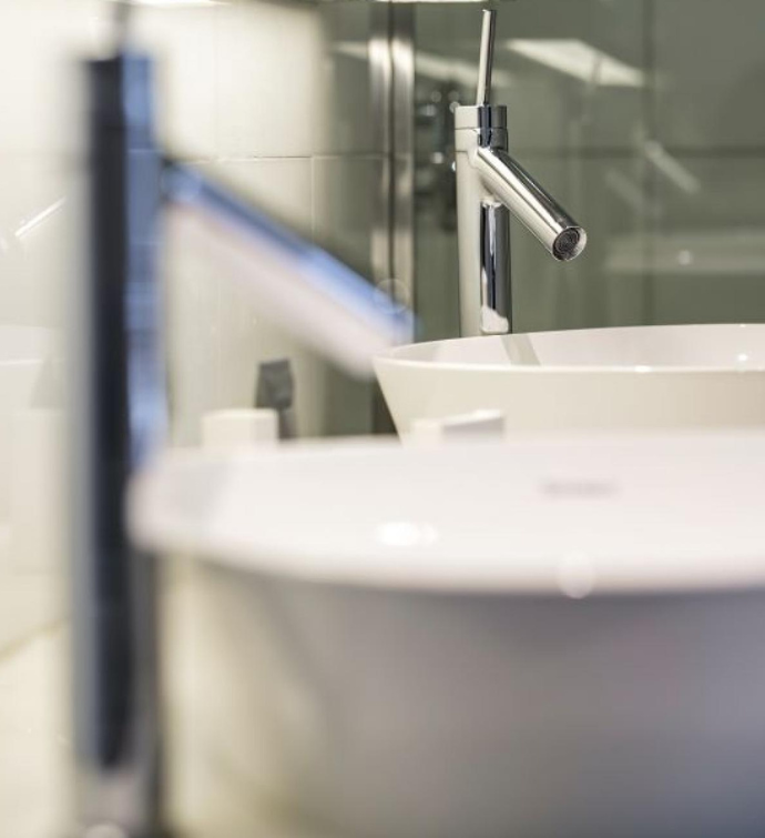 two sinks in a bathroom with white tile behind the faucets