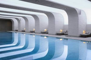 Indoor pool in a modern designed room, surrounded by lounging beds.