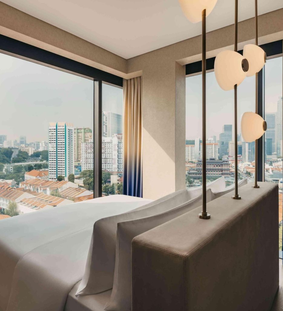 Hotel room with bed with modern lighting overlooking Singapore