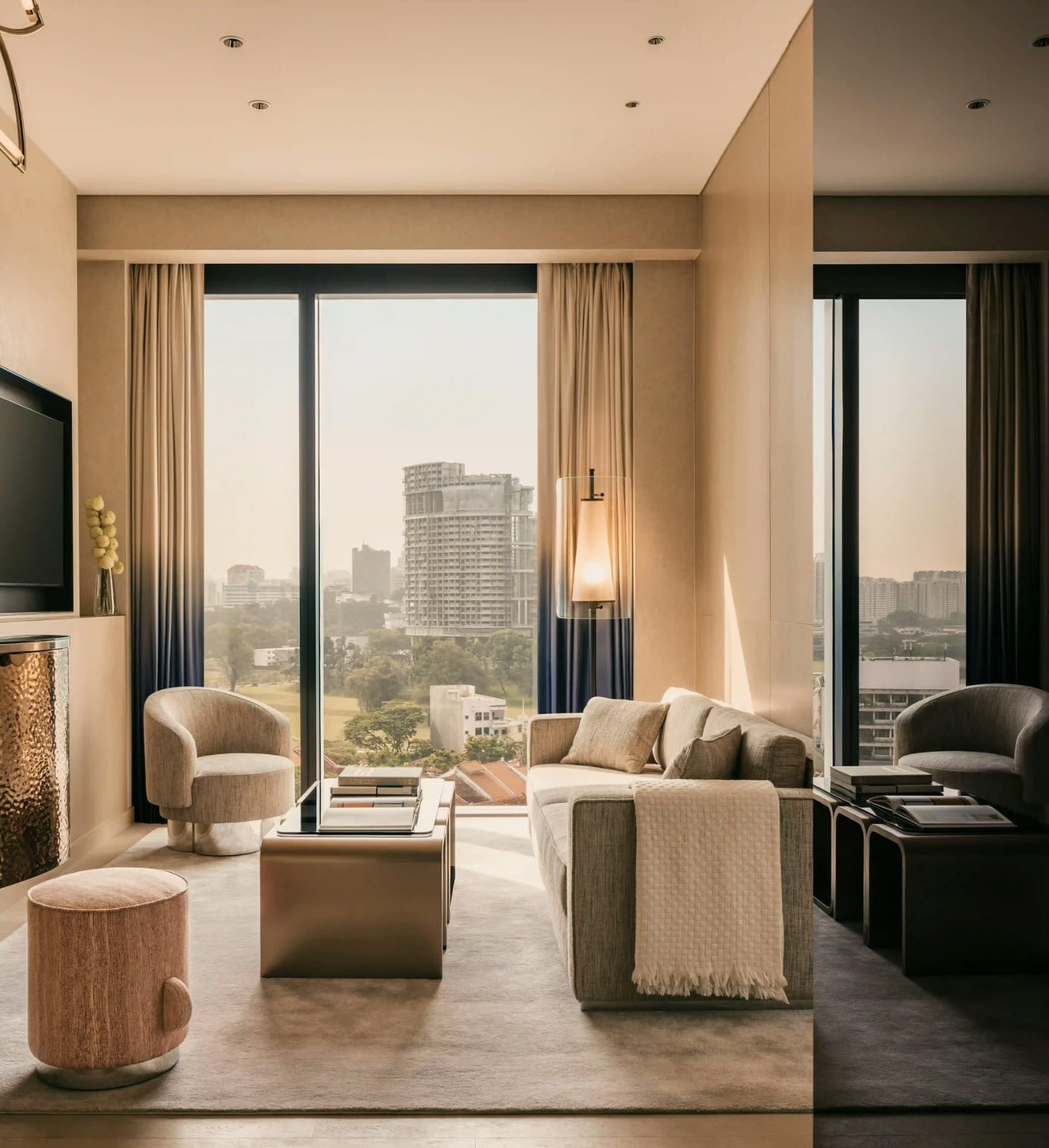 Modern living room area with TV, couch and floor to ceiling windows