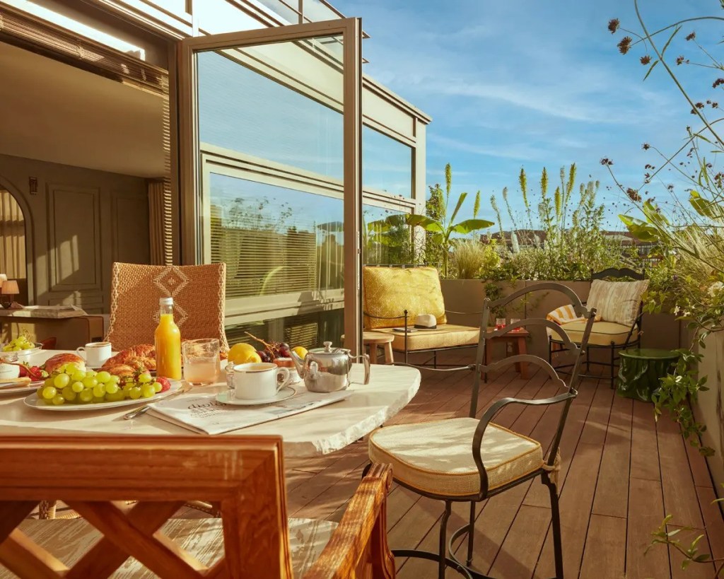 terraza al aire libre con plantas, sillas y una mesa