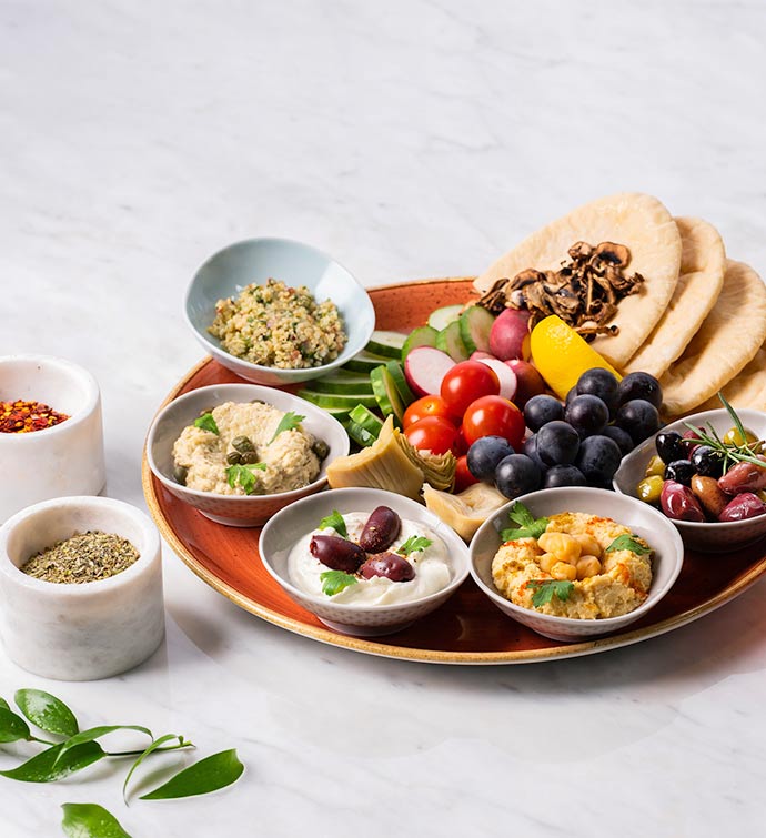 A mezze platter including olives, hummus, pita bread, vegetables and more