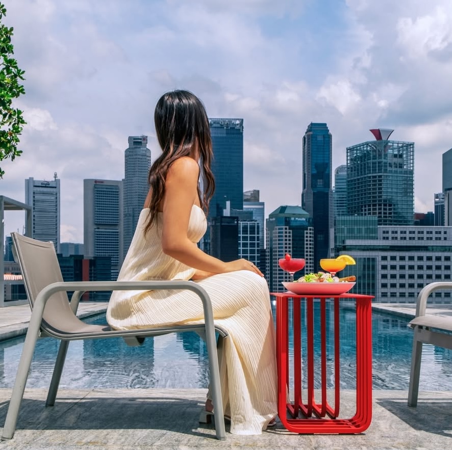 una mujer que está comiendo una ensalada y disfrutando de las vistas de la ciudad al fondo