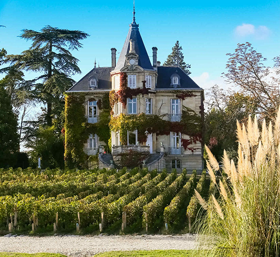 Château Les Carmes Haut-Brion en Burdeos, con viñedos y finca al fondo