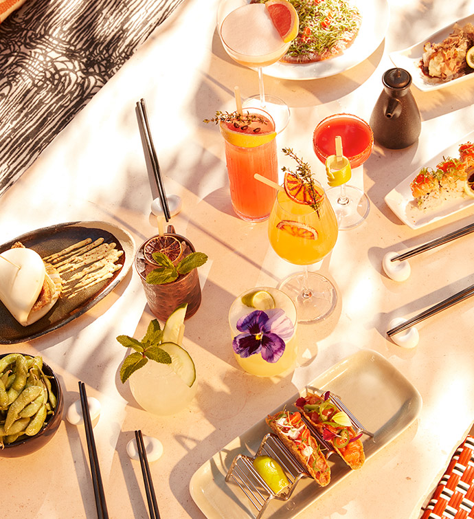 Assortiment de plats et de cocktails photographiés d’en haut, au soleil