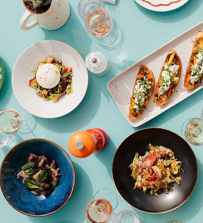 Una mesa azul claro con una selección de platos italianos frescos de Hyde Beach Cannes, fotografiada desde arriba