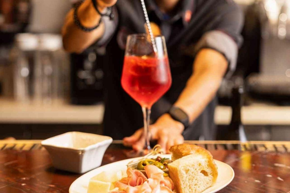 bartender preparing a cocktail with a plate of antipasto