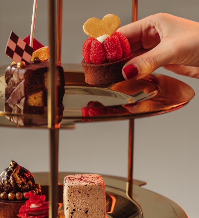 Plateau de service à plusieurs niveaux rempli de desserts au thé complet d’Alice au pays des merveilles