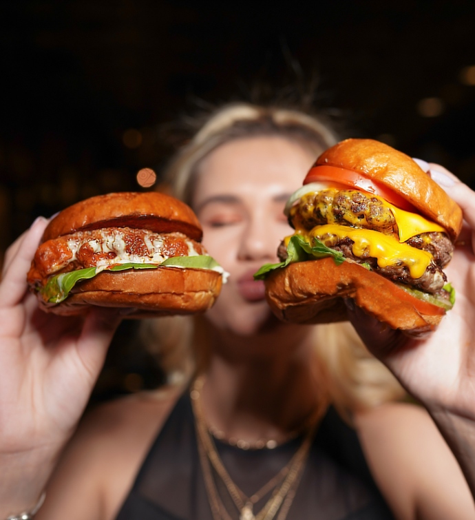 Mujer sosteniendo sándwiches en cada mano