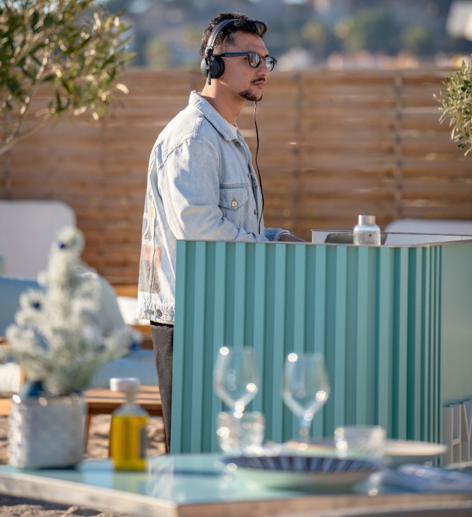 man in a teal dj booth at Hyde beach cannes