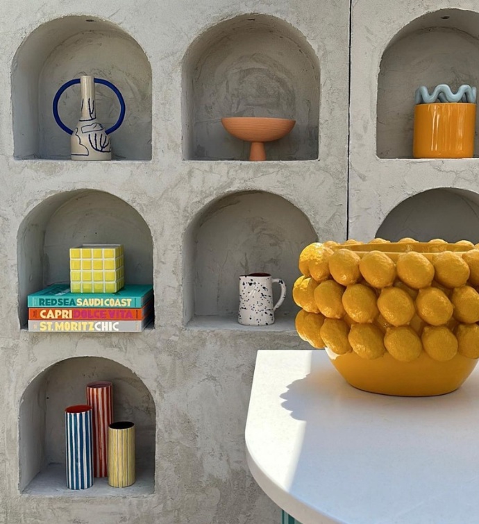 cement wall with pieces of art and books