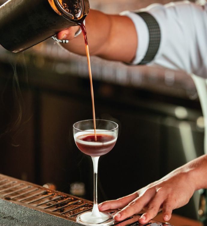 Coffee cocktail being poured by bartender