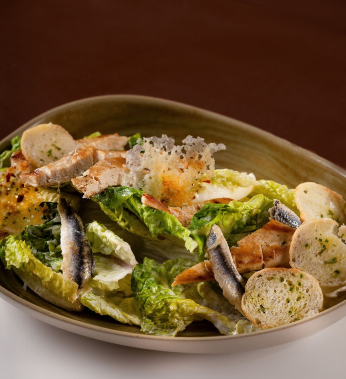 Ensalada César con picatostes, anchoas y trozos crujientes de parmesano