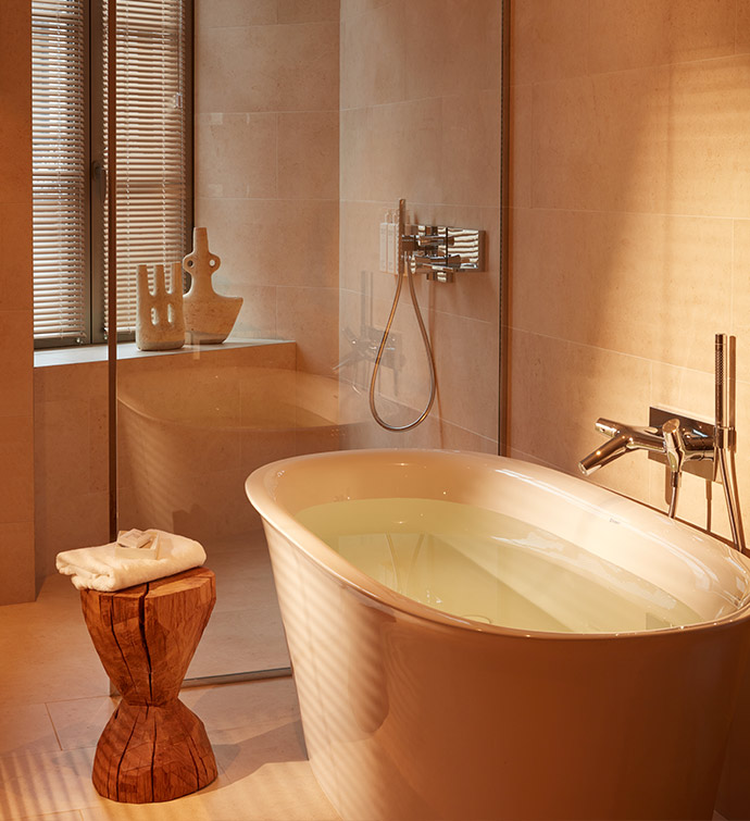 Salle de bains spacieuse avec une baignoire et une douche vitrée.