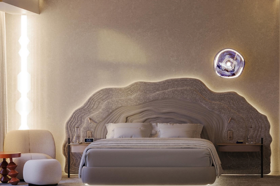 Modern large beige bed with rock-like carved headboard and pouf on the ground